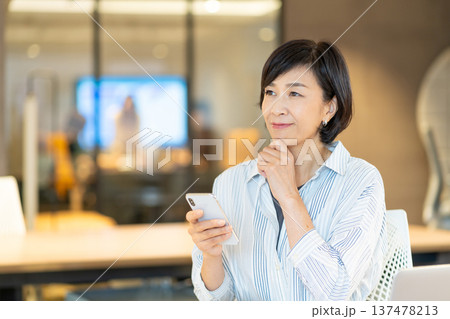 スマートフォンを操作するシニア女性 スマートフォンを操作するシニア女性 137478213