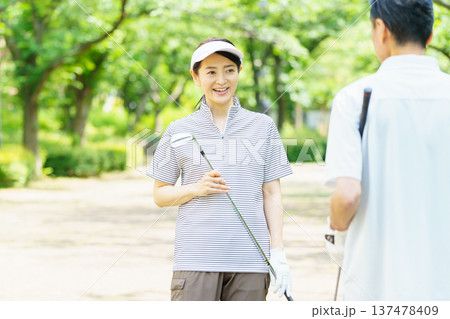 ゴルフ場で会話をするシニア夫婦 137478409