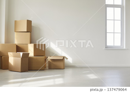 Cardboard Boxes Stacked in Bright Empty Room Near Window Cardboard Boxes Stacked in Bright Empty Room Near Window 137479064
