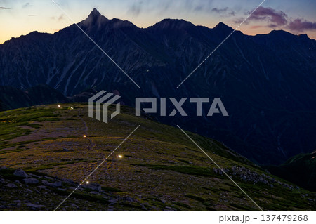 双六岳から見る夜明けの北アルプス・槍ヶ岳と登山者のライト 137479268