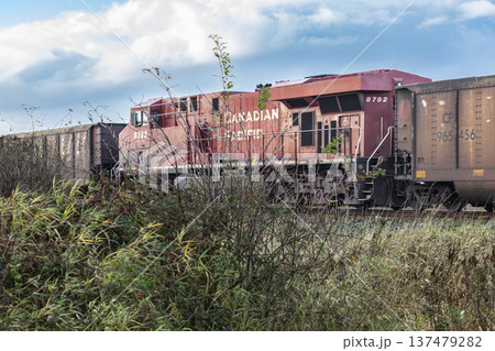 Freight train carrying containers passing through countryside in Canada. 137479282