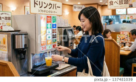ファミレスのドリンクバーでカップにジュースを注ぐ女性 ファミレスのドリンクバーでカップにジュースを注ぐ女性 137481039