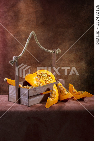 A ripe pumpkin cut into pieces on a table A ripe pumpkin cut into pieces on a table 137482126