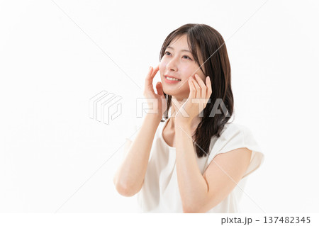 白背景でスキンケアをする女性のビューティーイメージ 137482345