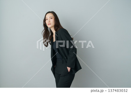 グレーバックの若い日本人女性の黒いスーツを着たファッションポートレート グレーバックの若い日本人女性の黒いスーツを着たファッションポートレート 137483032