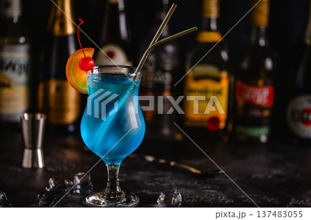 Glass of blue lagoon cocktail decorated with orange and cherry 137483055