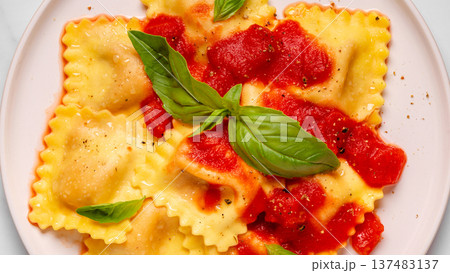 Delicious appetizing ravioli with tomato sauce and basil Delicious appetizing ravioli with tomato sauce and basil 137483137