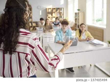 Teacher addressing students during classroom lesson and group discussion 137485494