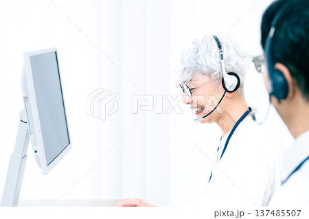 ヘッドセットをつけてパソコン操作をするシニア女性 137485507