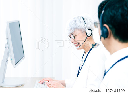 ヘッドセットをつけてパソコン操作をするシニア女性 137485509