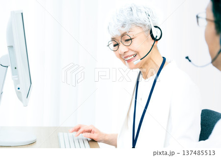 ヘッドセットをつけてパソコン操作をするシニア女性 ヘッドセットをつけてパソコン操作をするシニア女性 137485513