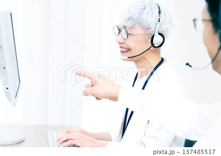 ヘッドセットをつけてパソコン操作をするシニア女性 137485517