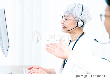 ヘッドセットをつけてパソコン操作をするシニア女性 137485518