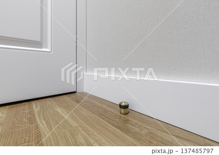 Modern Interior Door Stop on Oak Floor with White Skirting Board 137485797