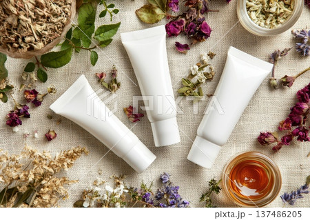 Elegant Arrangement of White Cosmetic Tubes on Linen with Herbal Decorations 137486205
