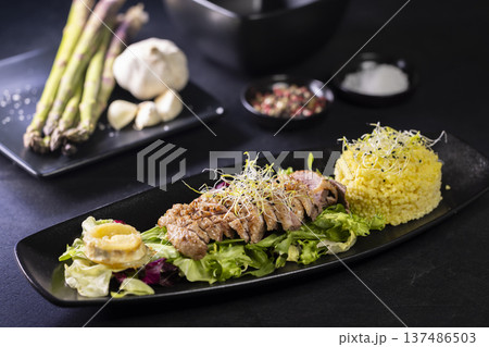 Gourmet duck breast meal with couscous and fresh vegetables 137486503