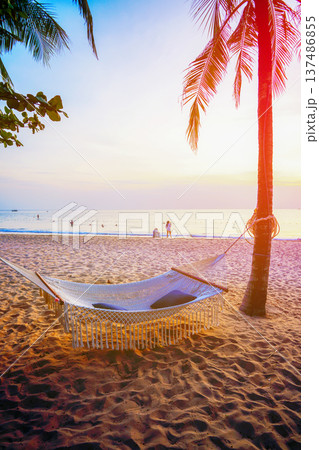 Hammock on sea beach on sunset. People on seaside. Island holiday. 137486855