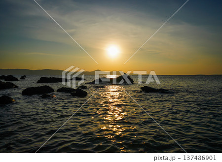 Sunset over sea on summer evening in coastal. Waves at rocks shore. 137486901