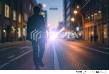 Silhouette of mysterious man walking on city street at night with bright car headlights, a concept for urban mystery story 137487624