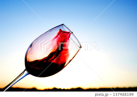 Red Wine Swirling background. Vibrant red wine is splashing out glass, creating droplets Red Wine Swirling background. Vibrant red wine is splashing out glass, creating droplets 137488199