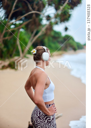 Woman In Summer Resort Attire. Relaxed Summer Style Showcased Amidst Vibrant Green Palm Leaves 137488328