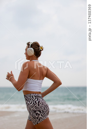 Runner On Beach. Dedicated Athlete Practices Endurance By Jogging Solitary Along Tranquil Ocean Coast 137488369
