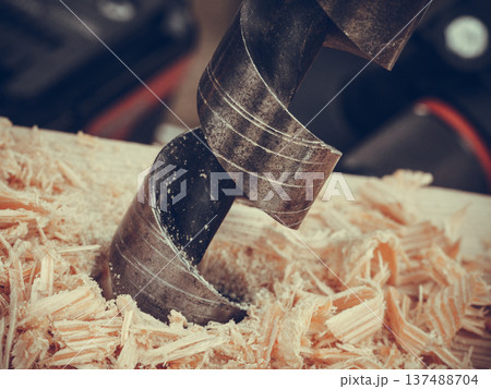 Metal machine drilling in wooden board 137488704