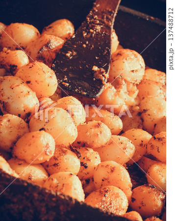 Backed young potatoes with spices in bowl 137488712
