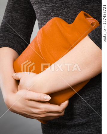 Girl having stomach ache, holding hot water bottle Girl having stomach ache, holding hot water bottle 137488721