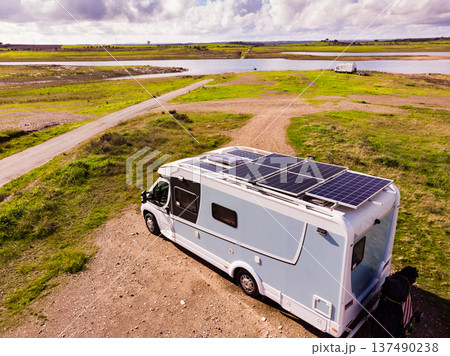 Caravan solar panels on roof camping on lake shore. Aerial view 137490238
