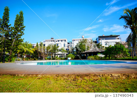 Swimming pool with turquoise water surrounded by dreamy beach hotel buildings 137490343