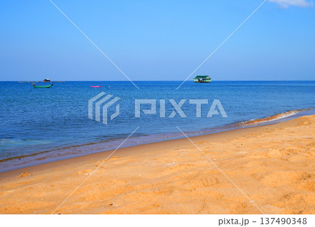 Fishing boat in sea on blue sky. View on ocean from beach. Fishing boats in sea along shore. 137490348