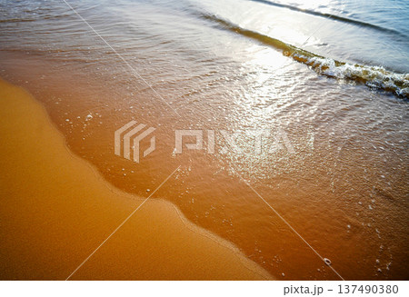 Waves at sea on dramatic sunset background. Sea waves at beach. Waves on sea in calm weather Waves at sea on dramatic sunset background. Sea waves at beach. Waves on sea in calm weather 137490380
