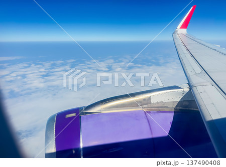 Airplane window view in flight. View on clouds from low-cost airline. Airplane window view in flight. View on clouds from low-cost airline. 137490408