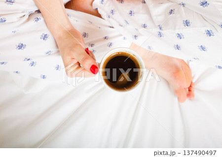 woman on bed with cup of coffee 137490497