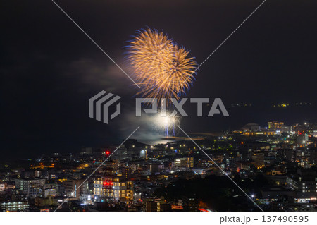 沖縄県名護市名護城公園さくらの園 琉球寒緋桜が咲く高台からの名護市街の夜景と海岸の打ち上げ花火 沖縄県名護市名護城公園さくらの園 琉球寒緋桜が咲く高台からの名護市街の夜景と海岸の打ち上げ花火 137490595
