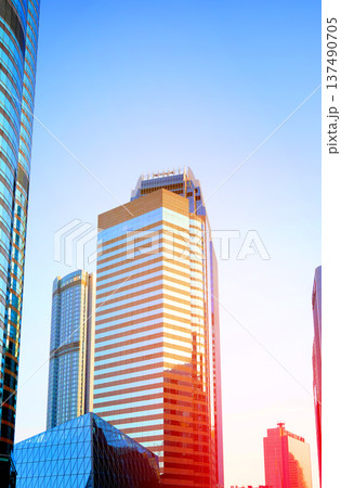 Skyscrapers in bright glass exteriors sunlight on sunset. Modern facade office buildings Skyscrapers in bright glass exteriors sunlight on sunset. Modern facade office buildings 137490705