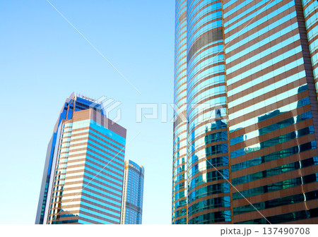 Skyscrapers in bright glass exteriors sunlight on sunset. Modern facade office buildings Skyscrapers in bright glass exteriors sunlight on sunset. Modern facade office buildings 137490708