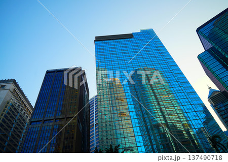 Skyscrapers in bright glass exteriors sunlight on sunset. Modern facade office buildings Skyscrapers in bright glass exteriors sunlight on sunset. Modern facade office buildings 137490718