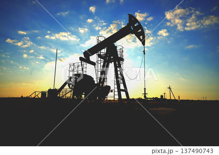 Pumpjack in oil well of oil field on sunrise in Industrial crude area. Crude pump jack on oil field Pumpjack in oil well of oil field on sunrise in Industrial crude area. Crude pump jack on oil field 137490743