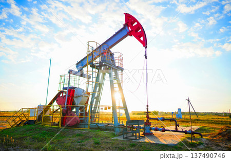 Pumpjack in oil well of oil field on sunrise in Industrial crude area. Crude pump jack on oil field Pumpjack in oil well of oil field on sunrise in Industrial crude area. Crude pump jack on oil field 137490746