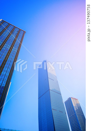 Skyscraper Facade building background in bright glass sunset. Modern facade office buildings Skyscraper Facade building background in bright glass sunset. Modern facade office buildings 137490758