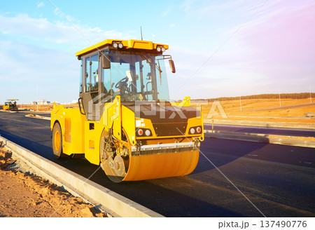 Road Asphalting construction. Asphalt paving repair. Vibrator compactor machine on roadworks 137490776