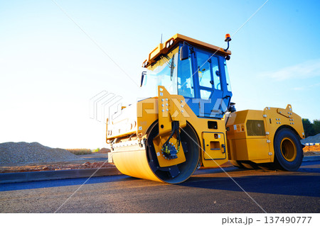 Road Asphalting construction. Asphalt paving repair. Vibrator compactor machine on roadworks 137490777