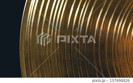 Drum cymbal close-up on a dark background, top view. 137490826