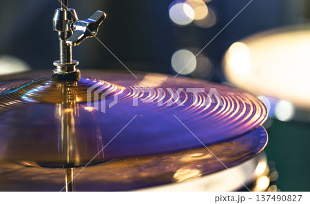 Drum cymbal close-up on a dark blurred background. 137490827