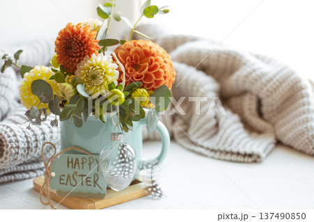 Easter composition with a bouquet of flowers and a knitted element. 137490850