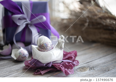 Easter composition with an egg and a gift on a blurred background. 137490876