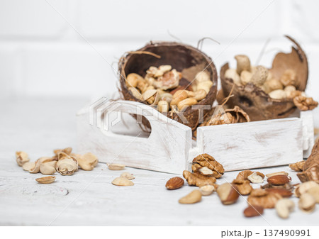 different nuts closeup on white wooden background 137490991