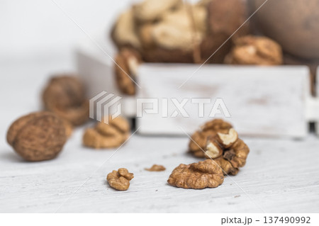 different nuts closeup on white wooden background different nuts closeup on white wooden background 137490992